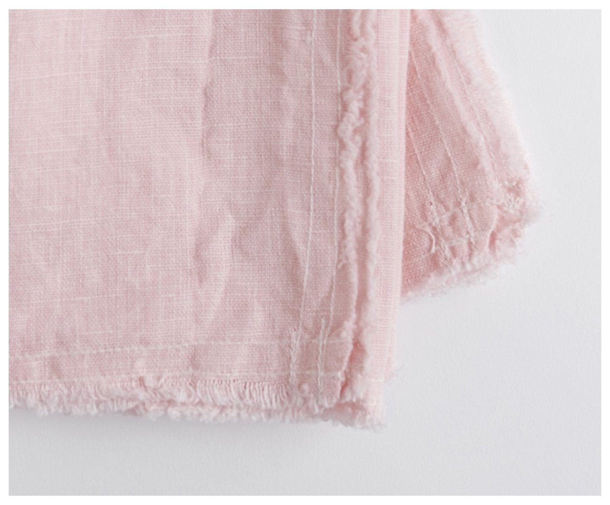 Linen napkin in light pink featuring an unfinished edge. celina mancurti