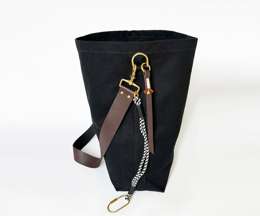 Black bag with leather strap and chain on a white background